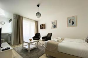 1 dormitorio con 1 cama, 2 sillas y TV en Atempo Residence, en Budapest