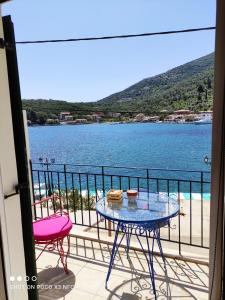 een balkon met een tafel en uitzicht op het water bij Fabulous apt. w/breakfast near the sea! in Sivota