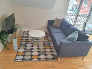 sala de estar con sofá azul y alfombra en Veversmauet Apartments, en Bergen