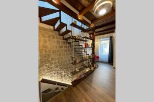 ein Wohnzimmer mit einer Ziegelwand und einer Treppe in der Unterkunft DOMUS TUSCIA APARTMENTS Via Estrema 2 in Viterbo