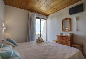 a bedroom with a bed with a window and a dresser at Hotel Rosamar - Emar Hotels in Es Pujols