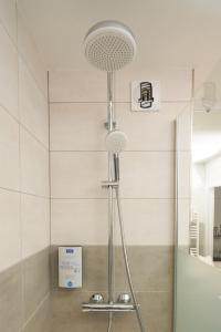 a shower with a shower head in a bathroom at Kyriad Limoges Sud - Feytiat in Feytiat