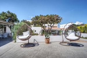 two metal chairs sitting on a patio at Hotel Rosamar - Emar Hotels in Es Pujols