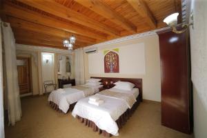 a group of four beds in a room at Kavsar Boutique Hotel in Bukhara
