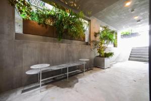 a room with two tables and plants on the wall at Ken's Place Azabudai in Tokyo
