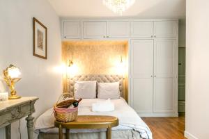 Schlafzimmer mit einem Bett und einem Korb auf einem Tisch in der Unterkunft Maison Chanzy in Paris