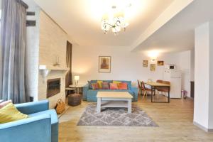 ein Wohnzimmer mit einem blauen Sofa und einem Tisch in der Unterkunft Luxury Mountain Apartment in Poiana Brașov