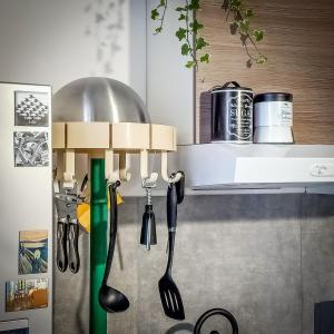 kuchnia z przyborami kuchennymi wiszącymi na blacie w obiekcie MR SQUARE apartment w Katanii
