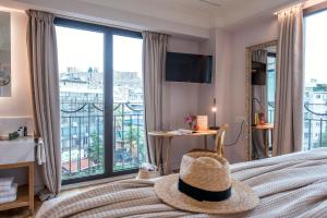 una camera da letto con un letto con un cappello sopra di Niche Hotel Athens ad Atene