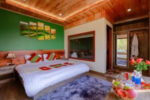 a bedroom with a large bed and green walls at Alley House Sapa Homestay in Sa Pa