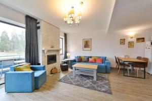 sala de estar con sofá azul y mesa en Luxury Mountain Apartment en Poiana Brasov