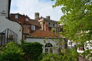 una casa vieja con un castillo en el fondo en Cathedral Gate, en Canterbury