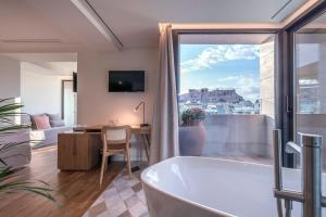 a bathroom with a tub and a table and a desk at Niche Hotel Athens in Athens