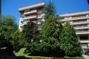 un edificio alto con árboles delante de él en SERENO REFUGIO en BARRIO RESIDENCIAL, en Añorga-Lugariz