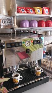 a coffee machine with two cups of coffee at Caicai Bed And Breakfast in Saluzzo