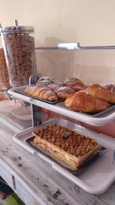 uma prateleira com três bandejas de pão e pastelaria em Caicai Bed And Breakfast em Saluzzo