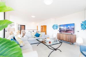 sala de estar con sofá blanco y TV en Ereza Villa Boraen, en Corralejo