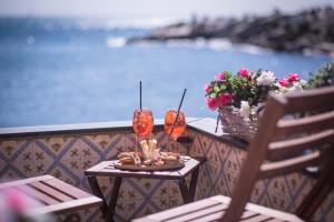 una mesa con 2 copas de vino en el balcón en Salsedine Relais, en Génova
