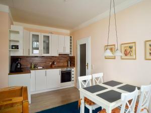 eine Küche und ein Esszimmer mit Tisch und Stühlen in der Unterkunft Strandvillen Binz - Ferienwohnung mit Meerblick, 2 Schlafzimmern und Balkon SV-012 in Binz