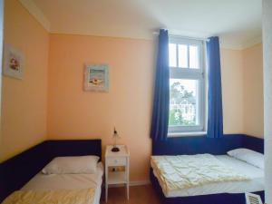 ein Schlafzimmer mit zwei Betten und einem Fenster in der Unterkunft Strandvillen Binz - Ferienwohnung mit Meerblick, 2 Schlafzimmern und Balkon SV-012 in Binz