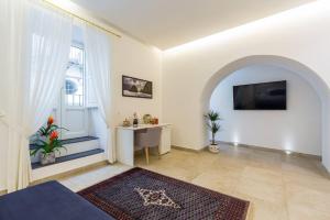 a living room with a tv and a table and a window at Casetta Fuoro Guest House in Sorrento
