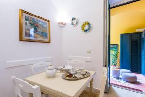 a dining room with a table and white chairs at Casetta Fuoro Guest House in Sorrento