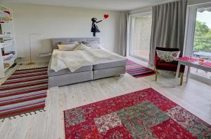 um quarto com uma cama e um tapete vermelho em fewo1846 - FlensView - komfortables Studioapartment mit Balkon und Hafenblick em Flensburg