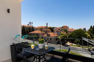 a table on a balcony with a view of a city at Apartments ZoomZoom in Dubrovnik