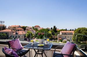 Una mesa y sillas en un balcón con vista. en Apartments ZoomZoom, en Dubrovnik