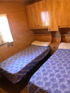 a small room with two beds in a cabin at Bungalós Las Nieves in Puebla de Lillo