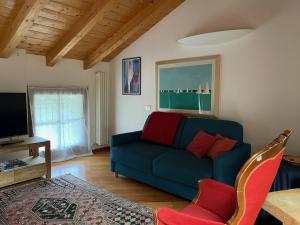 a living room with a blue couch and a tv at La Casa al Torrente in Riva del Garda