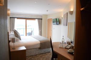 una camera d'albergo con letto, scrivania e finestra di The Chase Golf & Country Club a Penkridge
