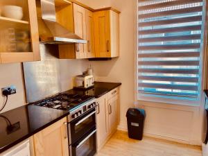 a kitchen with a stove top oven next to a window at Alexandra Beach Haven in Worthing