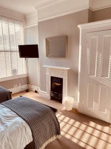 a bedroom with a bed and a fireplace at Alexandra Beach Haven in Worthing