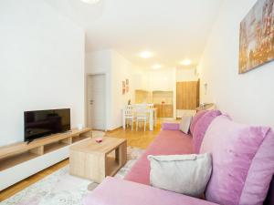 a living room with a purple couch and a tv at Peace 2 Apartments with parking in Budva