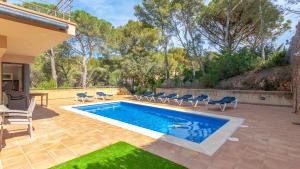 ein Pool im Hinterhof mit Stühlen drum herum in der Unterkunft VISTA ALEGRE in Tamariu