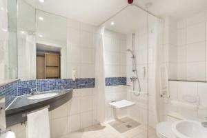 a bathroom with a shower and a sink and a toilet at Holiday Inn Express Royal Docks, an IHG Hotel in London