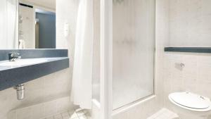 y baño con aseo, lavabo y ducha. en Holiday Inn Express Royal Docks, an IHG Hotel en Londres