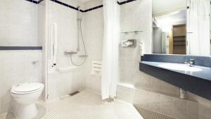 y baño con aseo, lavabo y ducha. en Holiday Inn Express Royal Docks, an IHG Hotel en Londres