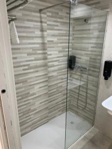 a bathroom with a shower stall and a glass door at Hotel Estrella Del Mar in Motril