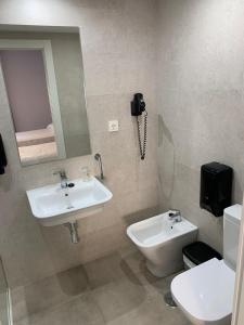 La salle de bains est pourvue d'un lavabo, de toilettes et d'un téléphone. dans l'établissement Hotel Estrella Del Mar, à Motril