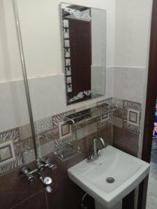 a bathroom with a sink and a mirror at New Taj Hotel in Lahore