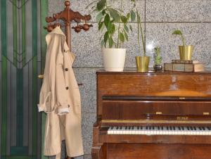 un cappotto è appeso accanto a un pianoforte di Boutique Hotel O. Galogre a Batumi