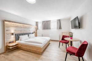A bed or beds in a room at Gasthof Schroll