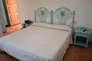 a bedroom with a bed with a blue headboard at Hotel Il Piccolo Golf in Porto Cervo