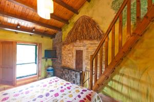a bedroom with a bed and a stone fireplace at Hotel Costa de Rodiles in Selorio