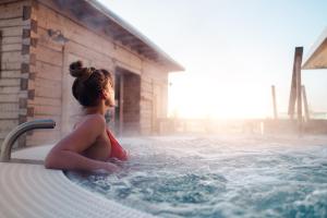 a young girl sitting in a hot tub at VALO Hotel & Work Helsinki in Helsinki