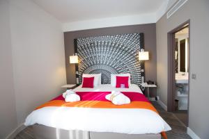 a bedroom with a large bed with red pillows at Mercure Nantes Centre Grand Hotel in Nantes