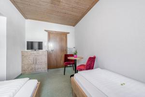 A bed or beds in a room at Gasthof Schroll
