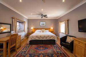 a bedroom with a bed and a desk and a tv at The Lodge in Hunstanton